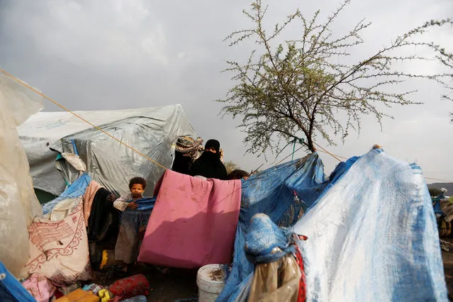 A woman and her son stand outside their hut at a camp for internally displaced people near Sanaa, Yemen, August 10, 2016. (Photo by Khaled Abdullah/Reuters)