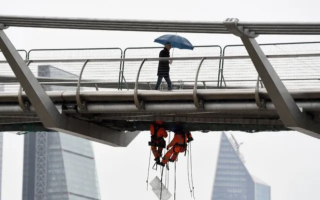 Workers make repairs on the Millennium Bridge in London, England on May 8, 2019. (Photo by James Veysey/Shutterstock)