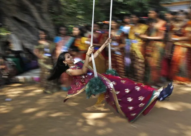 A student plays on a swing suspended from a tree inside a college complex during ongoing celebrations ahead of the south India's harvest festival of Pongal in the southern Indian city of Chennai January 12, 2013. (Photo by Babu/Reuters)