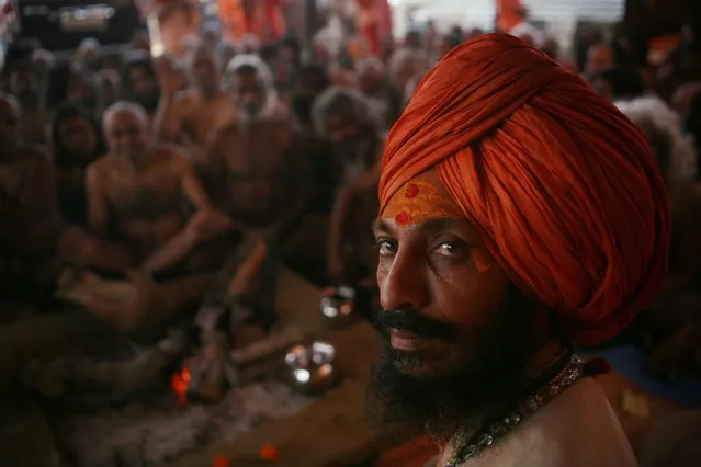 Hindu holy men of the Juna Akhara sect participate in rituals that are believed to rid them of all ties in this life and dedicate themselves to serving God as a “Naga” or naked holy men, at Sangam, the confluence of the Ganges and Yamuna River during the Maha Kumbh festival in Allahabad, India, Wednesday, February 6, 2013. The significance of nakedness is that they will not have any worldly ties to material belongings, even something as simple as clothes. This ritual that transforms selected holy men to Naga can only be done at the Kumbh festival. (Photo by Rajesh Kumar Singh/AP Photo)