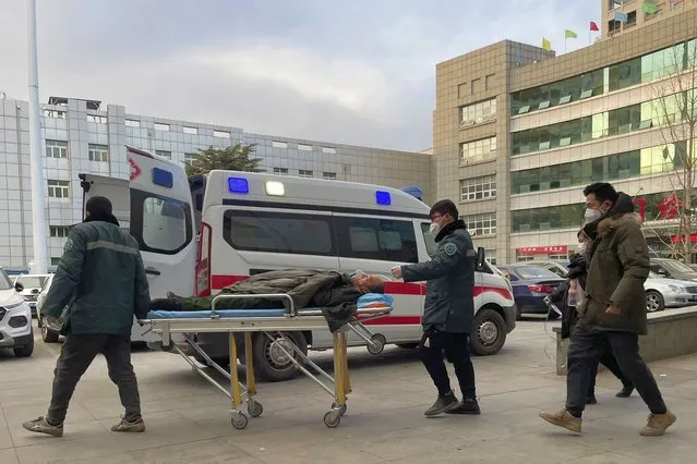 Medical workers push a man past an ambulance at the Baoding No. 2 Central Hospital in Zhuozhou city in northern China's Hebei province on Wednesday, December 21, 2022. (Photo by AP Photo/Stringer)