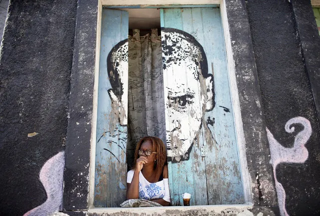 A woman looks from a window amid the new coronavirus pandemic at Morro da Providencia favela, Rio de Janeiro, Brazil, Thursday, September 3, 2020. Rio de Janeiro is deploying a program to administer 20 thousand COVID-19 quick tests in the city's poor neighborhoods to track the progress of the disease. (Photo by Silvia Izquierdo/AP Photo)