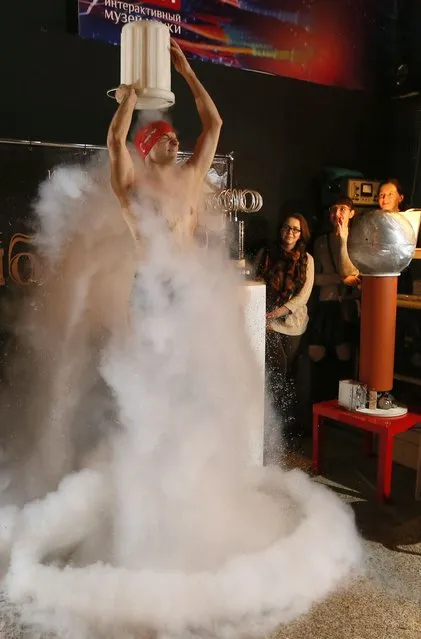 Ivan Timofeenko, co-founder of “Newton Park”, a private interactive museum of science, dumps a bucket of cold liquid nitrogen on himself during a flash mob at the Krasnoyarsk Museum Centre in Krasnoyarsk, Siberia, November 20, 2014. (Photo by Ilya Naymushin/Reuters)