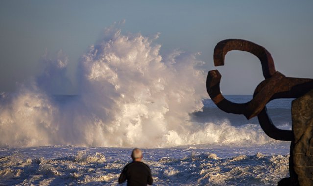 A man watches the waves in the early morning next to Eduardo Chillida's El Peine del Viento sculpture in San Sebastian, Spain, 07 November​ 2022. (Photo by Javier Etxezarreta/EPA/EFE)
