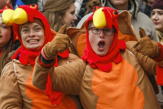 People react as they watch the 88th Macy's Thanksgiving Day Parade in New York November 27, 2014. (Photo by Eduardo Munoz/Reuters)