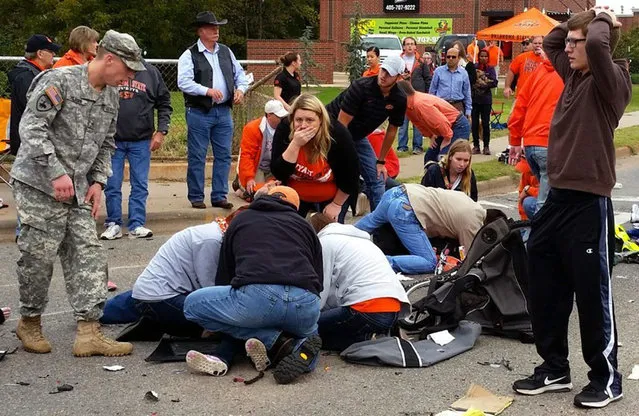 Bystanders help the injured after a vehicle crashed into a crowd of spectators during the Oklahoma State University homecoming parade, causing multiple injuries, on Saturday, October 24, 2015 in Stillwater, Oka. (Photo by David Bitton/The News Press via AP Photo)