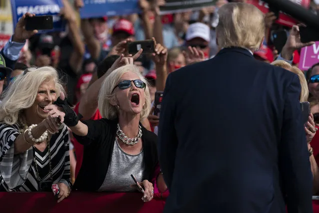 Supporters of President Donald Trump cheer as he walks off stage after speaking at a campaign rally at Pitt-Greenville Airport, Thursday, October 15, 2020, in Greenville, N.C. (Photo by Evan Vucci/AP Photo)