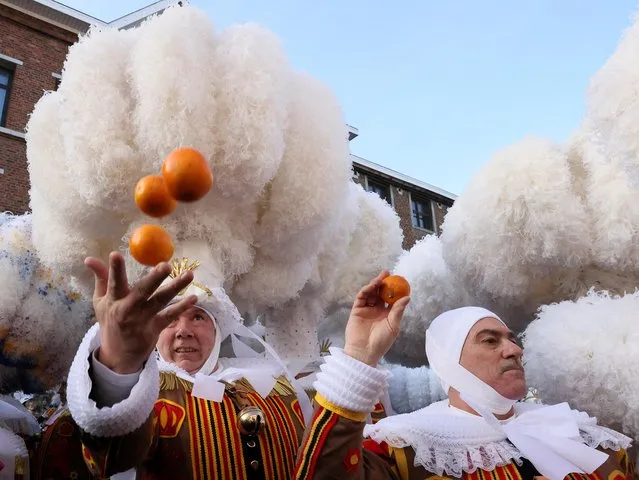 People wearing “Gilles” costumes throw oranges, during the Binche carnival, a UNESCO World Heritage event, in Binche, Belgium on February 21, 2023. (Photo by Yves Herman/Reuters)