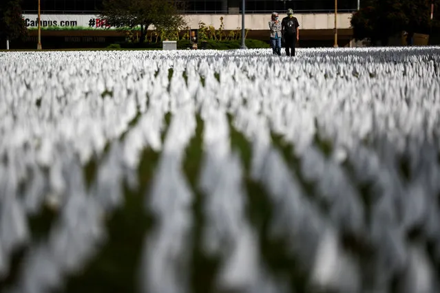 People look at the art installation “IN AMERICA How Could This Happen...” by artist Suzanne Brennan Firstenberg, as the spread of the coronavirus disease (COVID-19) continues, on the DC Armory Parade Ground, in Washington D.C., U.S., October 23, 2020. (Photo by Hannah McKay/Reuters)