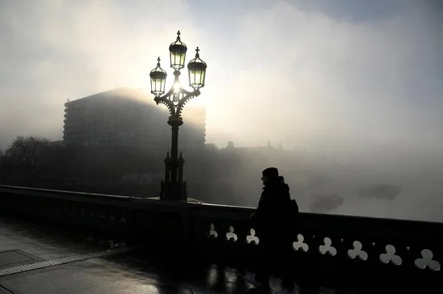 A person crosses Westminster Bridge during foggy weather in London, Britain on February 7, 2023. (Photo by Toby Melville/Reuters)