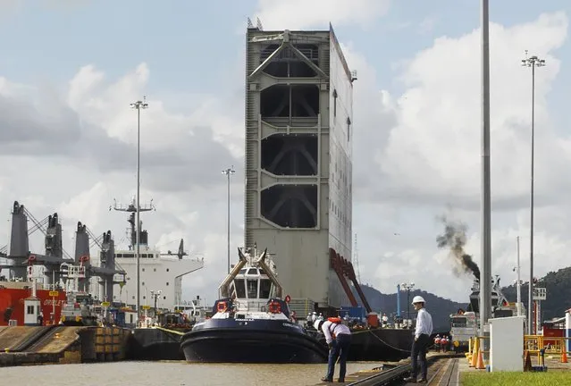 Tugboats help a barge transporting the last rolling gate for the new locks on the Pacific side of the Panama Canal through the Miraflores locks in Panama City December 10, 2014. (Photo by Rafael Ibarra/Reuters)