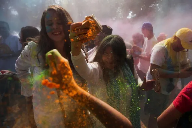 People take part in a symbolic Holi celebration organized by the Embassy of India, in San Salvador, El Salvador on March 4, 2023. (Photo by Jose Cabezas/Reuters)