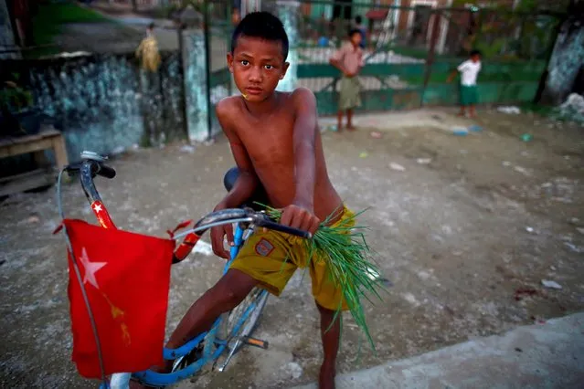 A boy stands with his bike adorned with the National League for Democracy party (NLD) flag in Yangon, Myanmar on  October 22, 2015. (Photo by Soe Zeya Tun/Reuters)