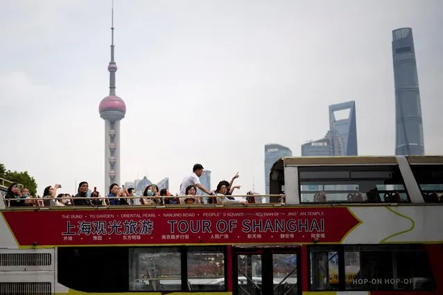 Tourists ride on a tourist double-decker bus in the Bund in Shanghai, China on March 15, 2023. (Photo by Aly Song/Reuters)