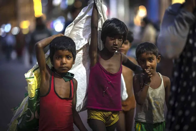 Street children collect recyclable materials in plastic bags from a market in Guwahati, India, Tuesday, March 14, 2023. (Photo by Anupam Nath/AP Photo)