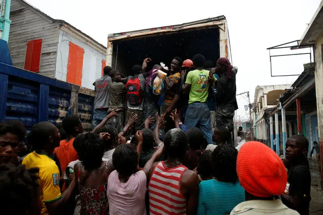 People assail a truck to try to get food after Hurricane Matthew hit Jeremie, Haiti, October 14, 2016. (Photo by Carlos Garcia Rawlins/Reuters)