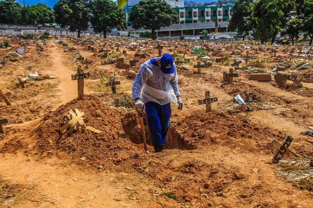 A worker buries a victim who died from COVID-19 at the Sao Francisco Xavier cemetery, in the Caju neighborhood, Rio de Janeiro, Brazil on December 16, 2020. (Photo by Ellan Lustosa/ZUMA Wire/Rex Features/Shutterstock)