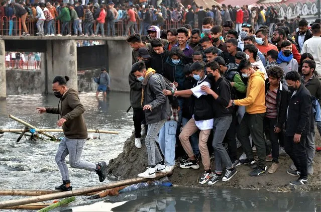 People try to cross the Bagmati River to avoid the crowded bridge at the premises of Pashupatinath Temple during the Shivaratri festival in Kathmandu, Nepal on February 18, 2023. (Photo by Navesh Chitrakar/Reuters)