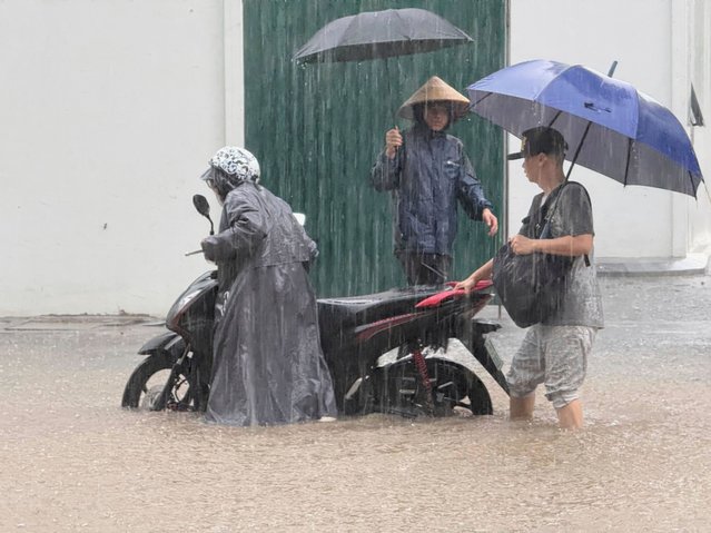 People push a motorbike through floods from heavy rains in Hanoi, after Typhoon Kajiki passed through Vietnam, Tuesday, August 26, 2025. (Photo by Hau Dinh/AP Photo)