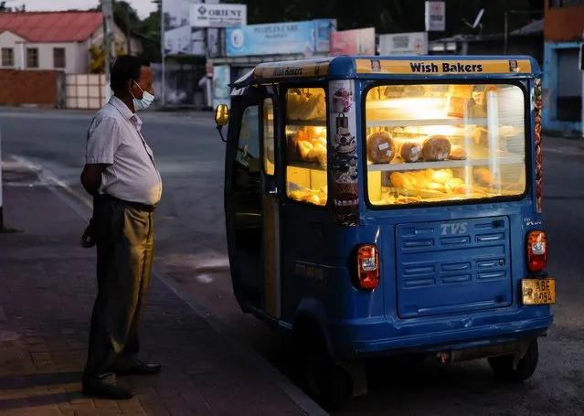 A man looks at bakery items kept in a mobile three-wheeler bakery near Wish Bakers shop, after the government announced a hike in power prices by 66%, in Colombo, Sri Lanka on February 18, 2023. (Photo by Dinuka Liyanawatte/Reuters)