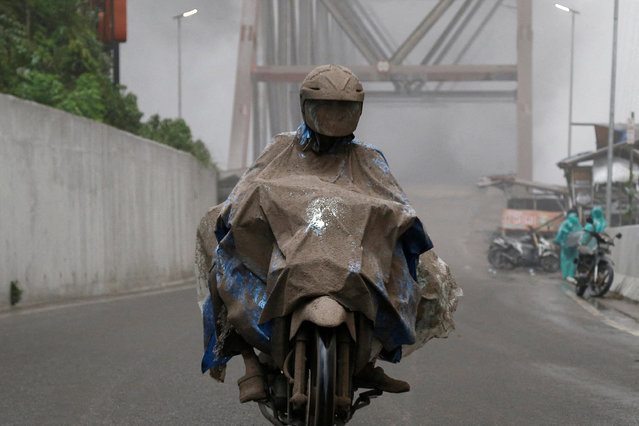 A resident, covered with volcanic ash, rides a motorbike past Besuk Kobo'an bridge, following Mount Semeru volcano eruption in Indonesia on November 21, 2025. (Photo by Dipta Wahyu/Reuters
