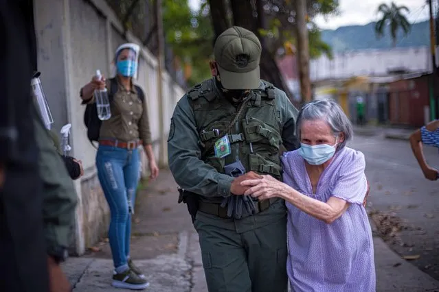 An elderly woman is helped by a soldier at the entrance to the San Jose de Calazans College Electoral Center in Valencia, Carabobo state, Venezuela on December 6, 2020. (Photo by Elena Fernandez/ZUMA Wire/Rex Features/Shutterstock)