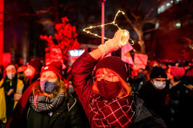 A demonstrator holds up a cloth hanger as she take part in a pro-choice demonstration in front of the constitutional court in Warsaw, Poland, on January 28, 2021, as part of a nationwide wave of protests since October 22, 2020 against Poland's near-total ban on abortion. - Hundreds of Poles rallied in Warsaw against a controversial court verdict imposing a near-total ban on abortion. Protesters also took to the streets elsewhere in the EU member in what was the second night of outrage after the Constitutional Court ruling came into effect on Wednesday, January 27, 2021. (Photo by Wojtek Radwanski/AFP Photo)