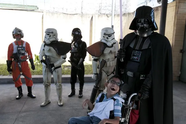 Cosplayers dressed as characters from the Star Wars movie series interact with a child during a charity event organised by Star Wars fan club El Salvador, at the “Eugenia Duenas” Blind Rehabilitation Center in San Salvador, El Salvador, December 10, 2015. (Photo by Jose Cabezas/Reuters)