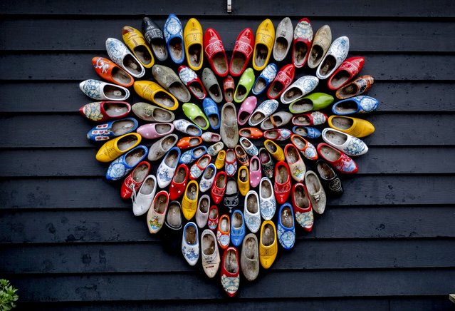 A heart is formed with Dutch clogs at the windmills museum of Zaanse Schan in Zaandijk, Netherlands, December 11, 2024. (Photo by Michael Probst/AP Photo)
