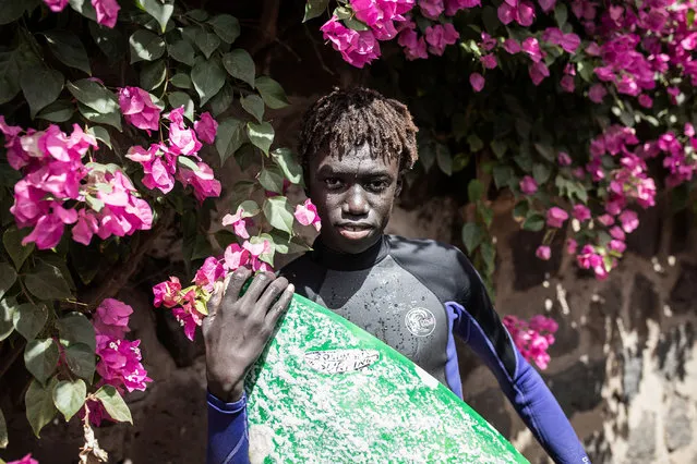 Young Senegalese surfer, Djibril, poses for a portrait on Ngor Island in Dakar on January 28, 2021. Surfing and surf culture in Dakar has exploded in the last years where a very tight-knit community focuses on bringing up the next generations of Senegalese surfers. As more Senegalese surfers find sponsors and global recognition the younger surfers see what’s possible and are pushing harder than ever to get there. (Photo by John Wessels/AFP Photo)