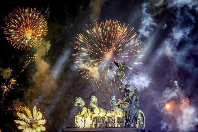 Fireworks light the sky above the Quadriga at the Brandenburg Gate during New Year's celebrations shortly after midnight in Berlin, Germany, Wednesday, January 1, 2025. (Photo by Ebrahim Noroozi/AP Photo)