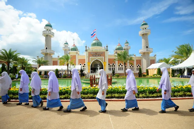 Girls walk past Pattani mosque whilst waiting for the arrival of Thai Crown Prince Maha Vajiralongkorn during a royal visit to the southern Thai province of Narathiwat on November 14, 2016. (Photo by Madaree Tohlala/AFP Photo)