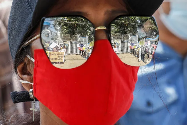 Demonstrators holding up placards outside the United Nations (UN) office are reflected on the sunglasses of a demonstrator during a protest against the military coup in Yangon, Myanmar, 16 February 2021. Myanmar's military junta on 16 February cut internet services for a second consecutive day as protests continued despite the deployment of troops and armoured vehicles in major cities. (Photo by Nyein Chan Naing/EPA/EFE)
