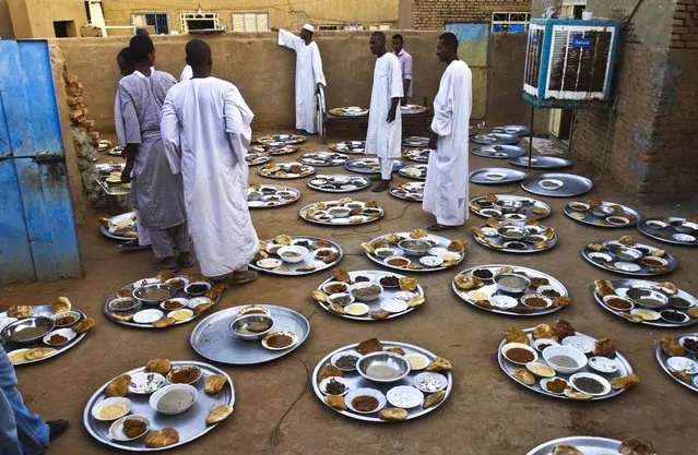 Muslims from the Qadiriyah Sufi order, prepare food for “Iftar” during the holy month of Ramadan, in Kabashi, Sudan, on July 24, 2013. Ramadan is the holiest month in Islam and observant Muslims worldwide mark it by fasting from dawn to dusk. (Photo by Abd Raouf/Associated Press)