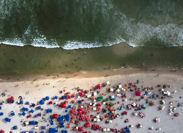 An aerial picture taken with a drone showing people spending time on the Barra de Tijuca beach, in the city of Rio de Janeiro, Brazil, 09 January 2021. Submerged in the second wave of the COVID-19 pandemic, Brazil is working against the clock to be able to start vaccination this month, a campaign that has been delayed and has become a prelude to the Presidential elections in 2022. (Photo by Antonio Lacerda/EPA/EFE)
