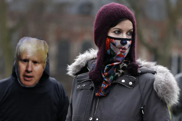 Protestors, one wearing a mask depicting Britain's Prime Minister Boris Johnson, assemble in Parliament square to demonstrate against the Police, Crime, Sentencing and Courts Bill, being debated in Parliament in London on March 15, 2021. (Photo by Adrian Dennis/AFP Photo)