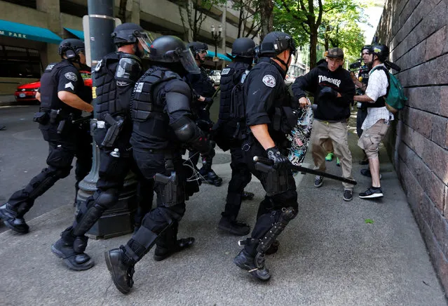 Police charge counter protestors during a rally by the Patriot Prayer group in Portland, Ore., August 4, 2018. (Photo by Bob Strong/Reuters)