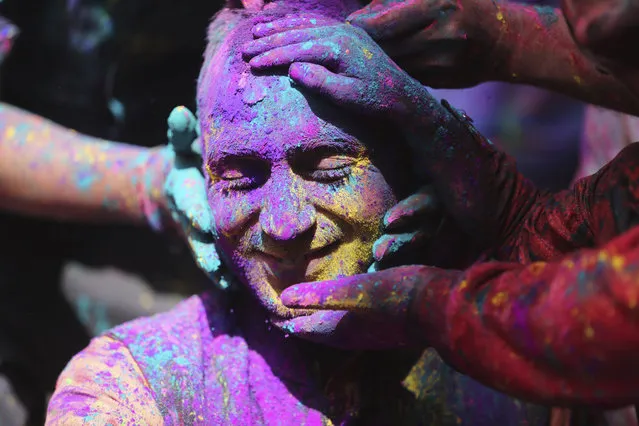 Indians smear colored powder on each other as they celebrate Holi in Jammu, India, Sunday, March 28, 2021. Holi, the Hindu festival of colors, also heralds the arrival of spring. (Photo by Channi Anand/AP Photo)