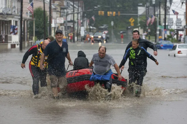 The Ryan Township dive team uses a boat to transport a person for medical problems along Pike Street in Port Carbon, Pa., on Monday, August 13, 2018. Overnight rains triggered flash flooding in parts of central and eastern Pennsylvania on Monday, closing down a heavily traveled interstate and sending water into homes in the mountainous coal regions. (Photo by David McKeown/Republican-Herald via AP Photo)