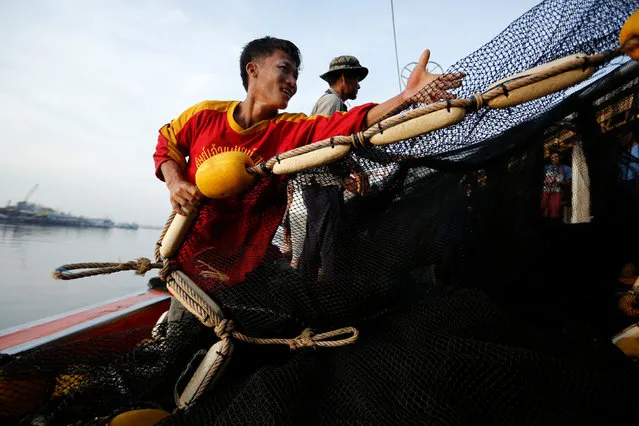 Fishermen pull a net after downloading their catch at Samut Sakhon port in Thailand November 22, 2016. (Photo by Jorge Silva/Reuters)