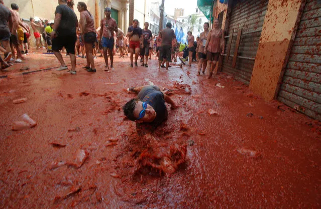 A reveller plays with tomato pulp during the annual Tomatina festival in Bunol, near Valencia, Spain on August 29, 2018. (Photo by Heino Kalis/Reuters)