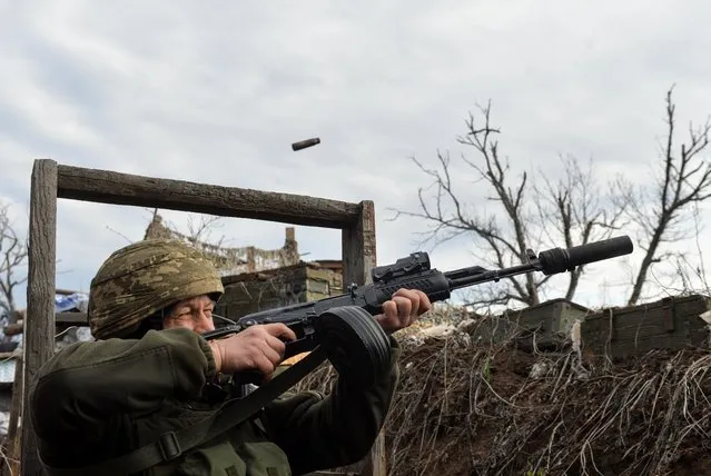 A service member of the Ukrainian armed forces fires in an attempt to shoot down an alleged unmanned aerial vehicle (UAV) at fighting positions on the line of separation from pro-Russian rebels near Donetsk, Ukraine on April 11, 2021. (Photo by Oleksandr Klymenko/Reuters)