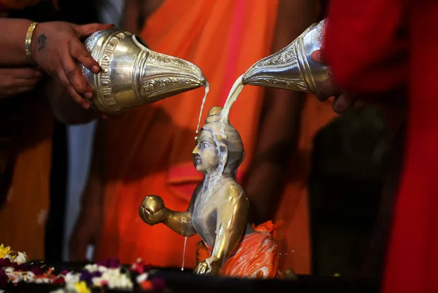 Hindu devotees pour milk over the idol of Hindu Lord Krishna during the festival of Janmashtami, marking the birth anniversary of Lord Krishna, in Ahmedabad, India, September 3, 2018. (Photo by Amit Dave/Reuters)