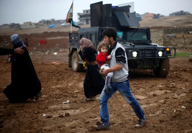 An Iraqi girl is carried by her brother as they flee the Islamic State stronghold of Mosul, in al-Samah neighborhood, Iraq December 1, 2016. (Photo by Mohammed Salem/Reuters)