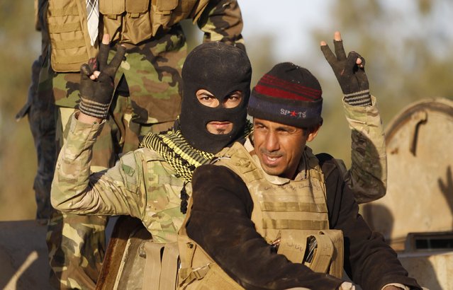 A Shi'ite fighter gestures during clashes with Islamic State militants in Salahuddin province March 2, 2015. Iraq's armed forces, backed by Shi'ite militia, attacked Islamic State strongholds north of Baghdad on Monday as they launched an offensive to retake the city of Tikrit and the surrounding Sunni Muslim province of Salahuddin.     REUTERS/Thaier Al-Sudani 