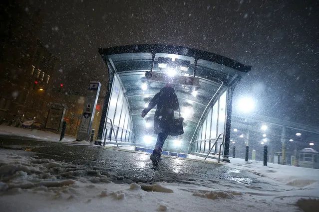 A commuter walks into the Hoboken PATH train station during a snowstorm, Saturday, January 23, 2016, in Hoboken, N.J. Towns across the state are hunkering down during the major snowstorm that hit overnight. (Photo by Julio Cortez/AP Photo)