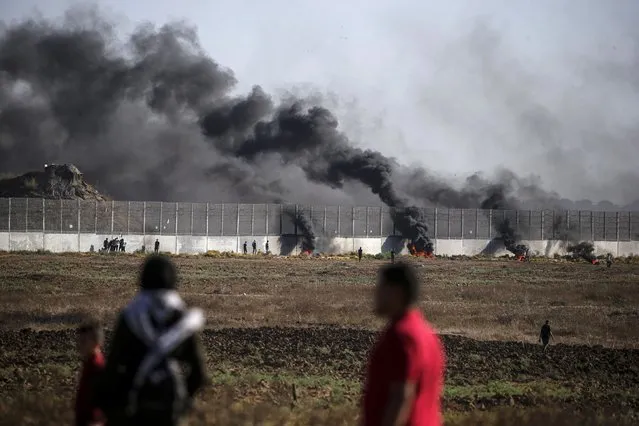 Palestinian protesters gather near the border wall during clashes with Israeli troops on the eastern border of the Gaza Strip, 15 September 2023. According to the Palestinian ministry of health, at least twelve Palestinian protesters were wounded during the clashes. (Photo by Mohammed Saber/EPA)