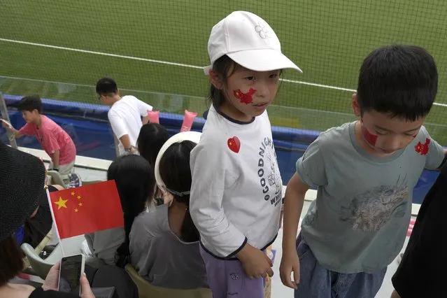 A child wears a face decal in the shape of China's map with the national flag colours attends a stage group round B Baseball Men game between Taiwan and Hong Kong for the 19th Asian Games in Hangzhou, China on Tuesday, October 3, 2023. At the Asian Games China has been going out of its way to be welcoming to the Taiwanese athletes, as it pursues a two-pronged strategy with the goal of taking over the island, which involves both wooing its people while threatening it militarily. (Photo by Ng Han Guan/AP Photo)