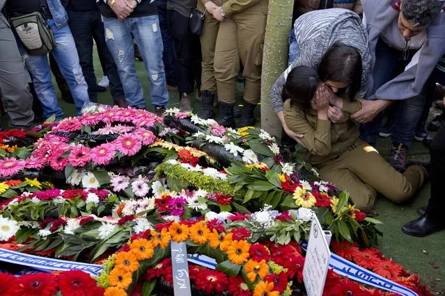 A friend mourns over the grave of Hadar Cohen, an Israeli female border police officer that was killed on Wednesday in Jerusalem attack   during her funeral in Yehud, near Tel Aviv, Israel, Thursday, February 4, 2016. Cohen was killed after three Palestinians armed with automatic weapons, explosive devices and knives killed an Israeli security officer and seriously wounded another in Jerusalem on Wednesday before police shot and killed the attackers. (Photo by Ariel Schalit/AP Photo)