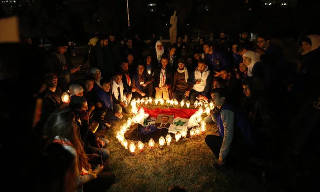 Syrians place candles, around the picture of Syrian President Bashar Assad, in the shape the Syrian map during a vigil fro peace at the Ummayyad Square in Damascus, Syria, 30 December 2016. (Photo by Youssef Badawi/EPA)